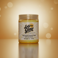 A jar of Let's Glow kojic acid & turmeric 100% cotton Pads on a reflective golden-brown surface with a matching bokeh background.